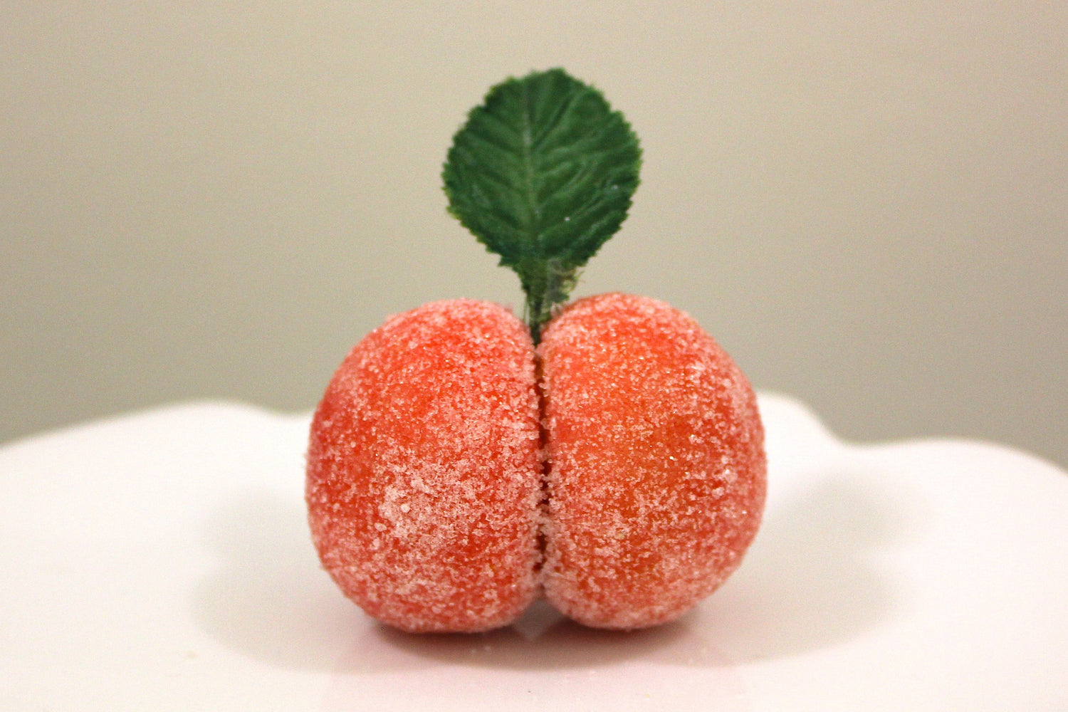 Decorative peach cookie on a white plate against a beige background