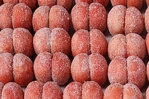 Close-up of italilan peach cookies, likely strawberry flavour, with a pinkish-red color.